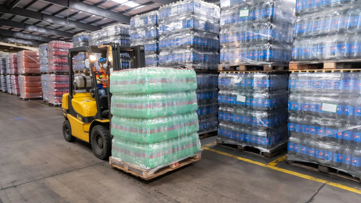 Professional forklift operator moving palletized goods in a modern warehouse