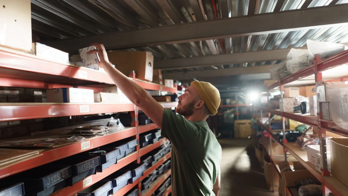 Warehouse worker picking an item from logistics storage shelves