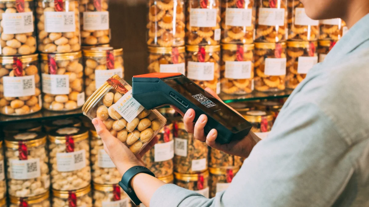 Supermarket worker scanning a grocery product while preparing an order